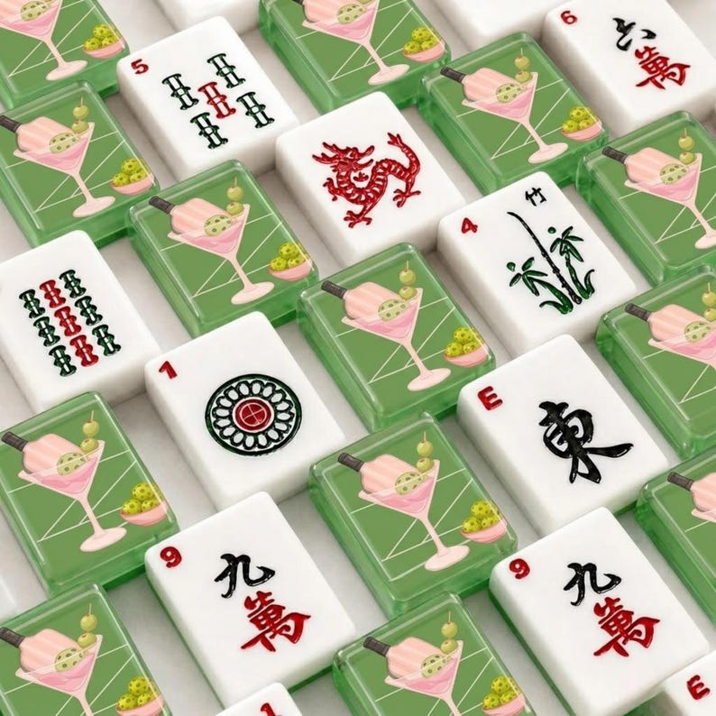 May include: A collection of white Mahjong tiles with various symbols and numbers. Some tiles feature a red dragon, bamboo, or a flower design. Other tiles have a cocktail design with green olives.