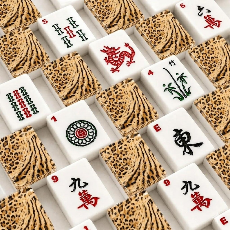 May include: A collection of mahjong tiles arranged in a grid pattern. Each tile features a white face with various red, green, and black symbols, numbers, or characters, paired with a textured brown and black leopard print pattern on the back.
