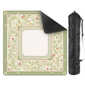May include: A square picnic blanket featuring a light green border with intricate scrolling foliage and small red and yellow floral accents surrounding a plain cream center. The blanket has a black underside and comes with a black carrying bag.