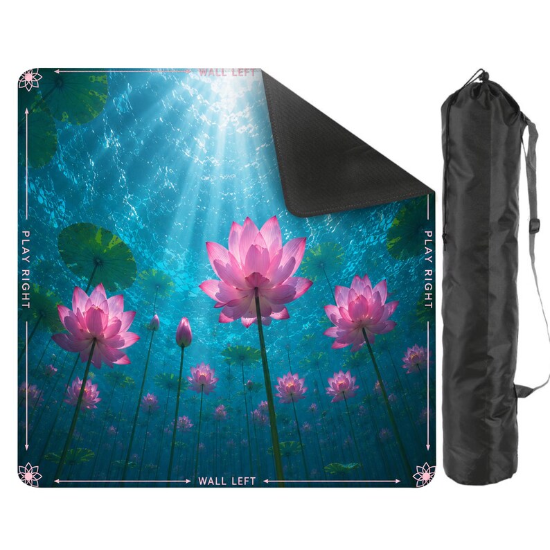 May include: A yoga mat featuring a vibrant underwater scene with pink lotus flowers and green lily pads. The mat is rectangular with a black backing and includes a black carrying bag with a shoulder strap. The words "PLAY RIGHT" and "WALL LEFT" are printed on the mat.