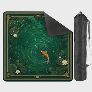 Pu&ograve; includere: Un tappetino quadrato raffigurante uno stagno verde scuro con un pesce koi arancione, ninfee e fiori di loto bianchi, incorniciato da un bordo dorato. Il tappetino &egrave; mostrato con un angolo ripiegato che rivela il retro nero e una borsa nera.