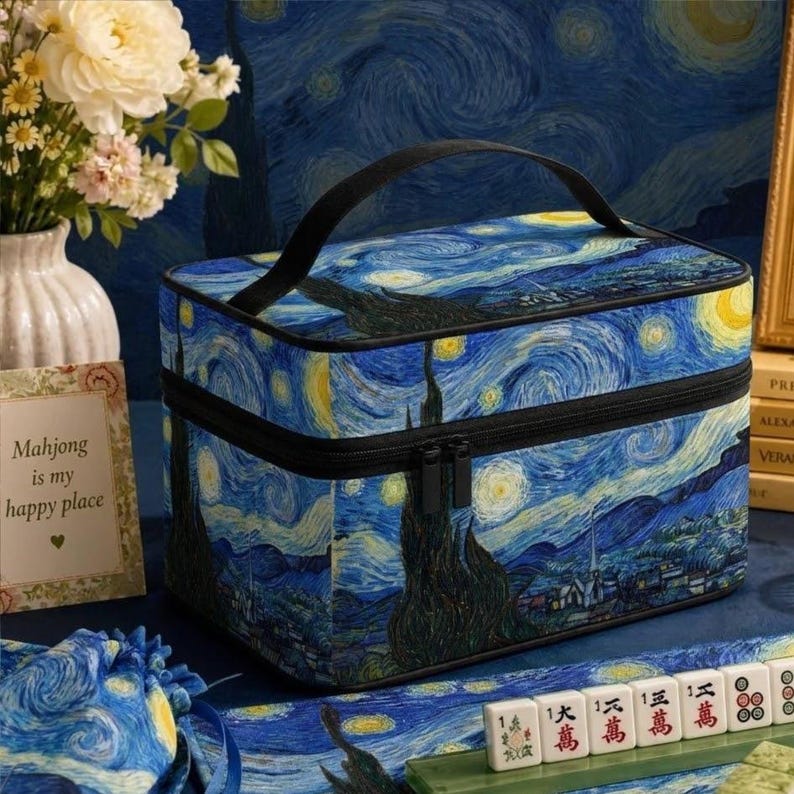 May include: A rectangular storage case featuring a Starry Night print with swirling blue, yellow, and black patterns. The case has a black top handle, a black zipper closure, and a structured design. It is decorated with a classic post-impressionist art style.