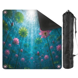 May include: A yoga mat featuring a vibrant underwater scene with pink lotus flowers and green lily pads. The mat has a black underside and is accompanied by a black carrying bag with a shoulder strap. Decorative lotus flower icons are in each corner.