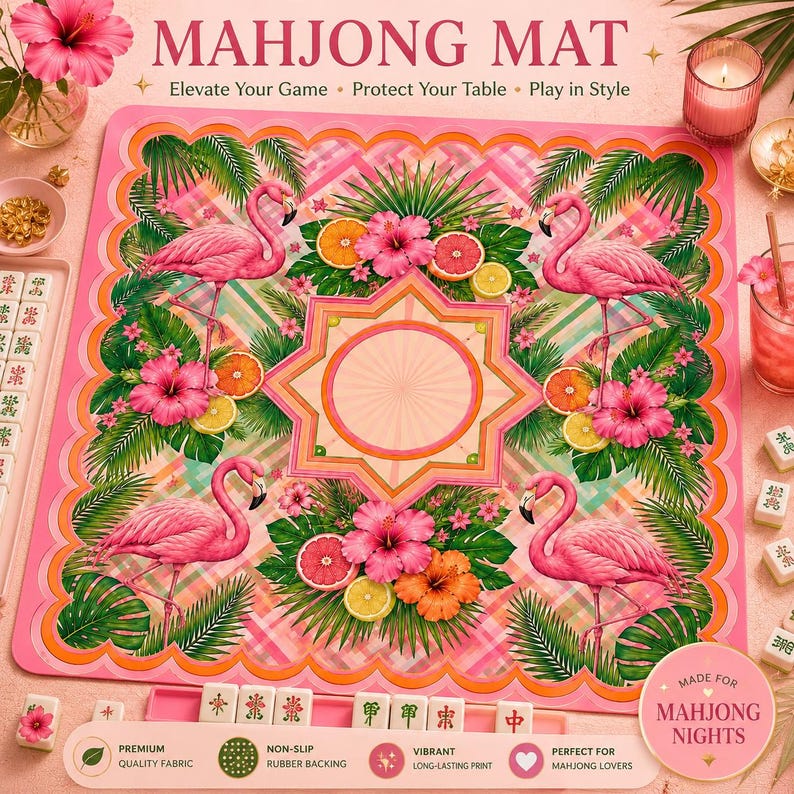 May include: Pink Mahjong mat with a flamingo and tropical fruit design. The mat features a central starburst design and is surrounded by a scalloped border. The text "MAHJONG MAT" is at the top.