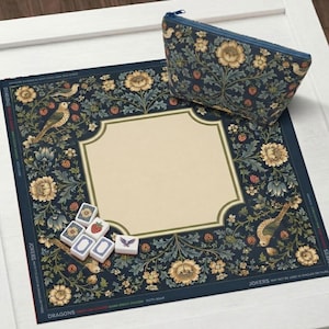 May include: A navy blue game mat and matching zipped pouch featuring a floral and bird pattern. The mat has a cream-coloured centre and is adorned with flowers, birds, and strawberries. Several game tiles are visible. The text "DRAGONS" and "JOKERS" is printed on the mat.