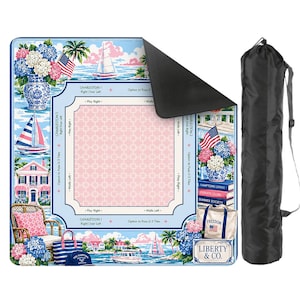 May include: A blue and pink picnic blanket with a coastal design, featuring sailboats, houses, and floral arrangements. The blanket includes the text "CHARLESTON 1" and "LIBERTY & CO." A black carrying bag is included.