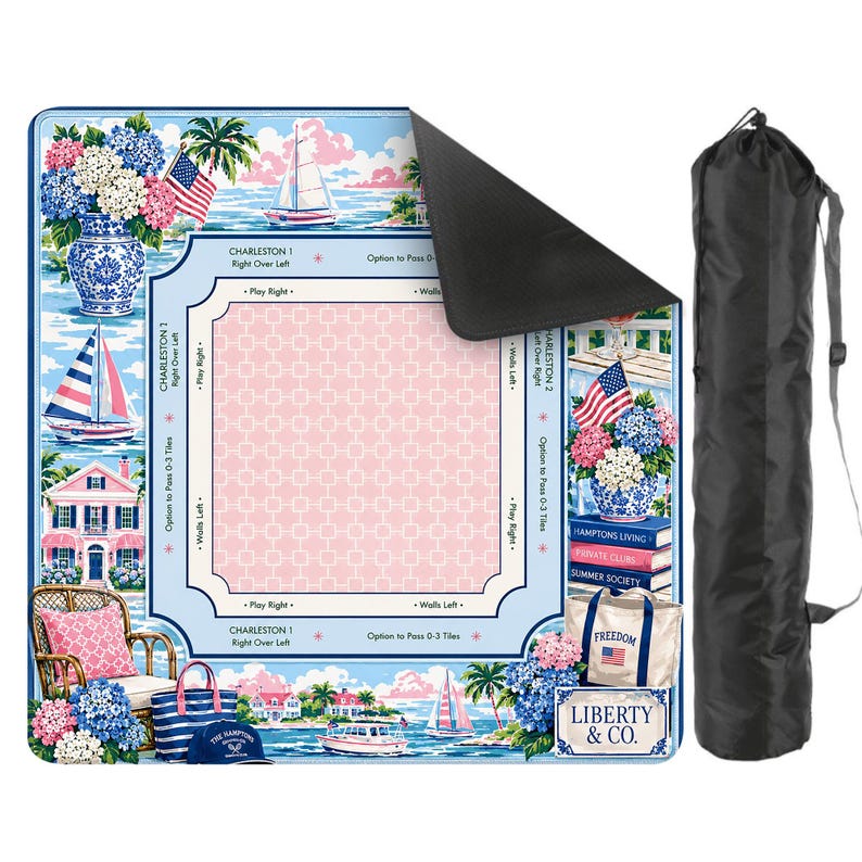 May include: A blue and pink picnic blanket with a coastal design, featuring sailboats, houses, and floral arrangements. The blanket includes the text "CHARLESTON 1" and "LIBERTY & CO." A black carrying bag is included.
