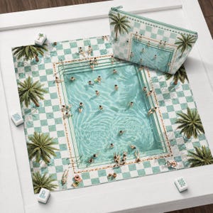 May include: A square mat and a matching zippered pouch featuring a light green and white checkered pattern with palm trees and a swimming pool filled with people. The design includes small rectangular tiles scattered around the mat.