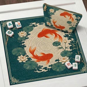 May include: A square mat and a zippered pouch featuring a dark teal background with orange koi fish, white lotus flowers, and green lily pads. The mat includes a central circular ripple pattern. Several small white tiles with symbols are scattered nearby.