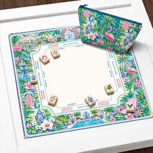 May include: A square Mahjong mat featuring a vibrant tropical garden print with flamingos, palm trees, and blue and white porcelain vases, accompanied by a matching zippered pouch and several ivory-colored tiles with floral and bird illustrations.