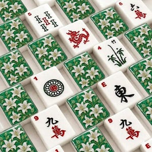 Pu&ograve; includere: Una collezione di tessere rettangolari da mahjong disposte in una griglia. Alcune tessere presentano gigli bianchi su sfondo verde, mentre altre mostrano caratteri cinesi neri e rossi, un drago rosso, un gambo di bamb&ugrave; e un emblema circolare.