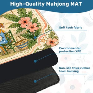 May include: A Mahjong mat featuring a beige surface with a floral and basket illustration, a middle layer of environmental protection XPE, and a black non-slip thick rubber foam backing. The top layer is made of soft tech fabric.