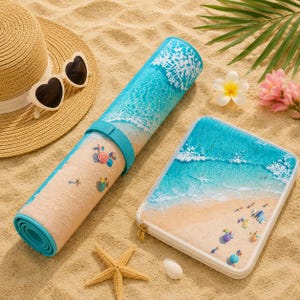 May include: A rolled beach mat and a rectangular zippered case, both featuring a printed design of turquoise ocean waves meeting a sandy shore with small beach umbrellas. A straw hat with heart-shaped sunglasses and a starfish are nearby.