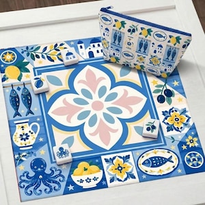 May include: A blue and white decorative mat with a floral and Mediterranean design, featuring lemons, fish, and octopus illustrations. A matching zippered pouch with a similar pattern is also present, along with several game tiles.