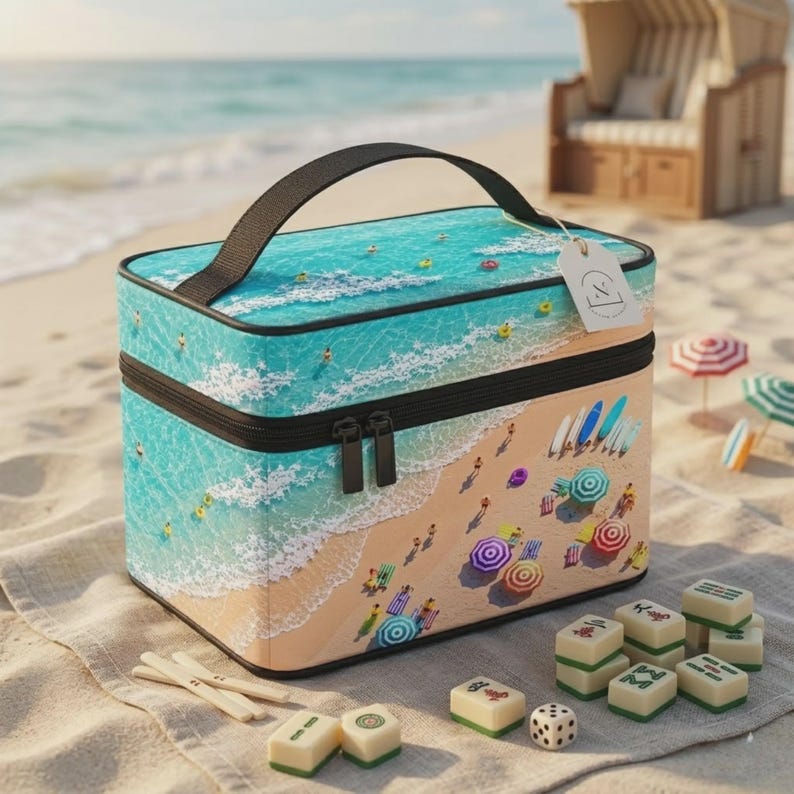 May include: A rectangular cosmetic bag featuring a beach scene print with turquoise ocean waves and sandy shores. The bag has a black handle, black zippers, and a white tag. Several small, rectangular, off-white game tiles are scattered nearby.