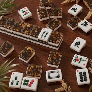 May include: A set of Mahjong tiles featuring a white base with a tortoiseshell-patterned back. Some tiles display black Chinese characters, red and green floral motifs, or numerical symbols, while others show a plain tortoiseshell design.