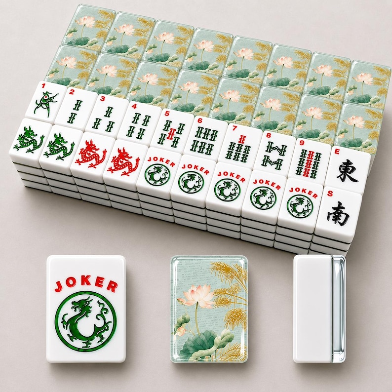 May include: A complete Mahjong set with white tiles featuring green and red symbols, numbers, and Chinese characters. The set includes tiles with a dragon and the word "JOKER". The tile box has a floral design.