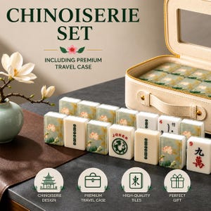 May include: A Chinoiserie set with a premium travel case. The set includes tiles with floral and character designs, and a "Joker" tile. The tiles are arranged on a dark surface next to a cream-colored travel case.