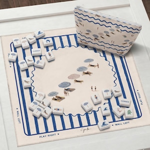 May include: A beach-themed game set with a matching zippered pouch. The game board features a beach scene with umbrellas and people. The game pieces have beach-related icons. The pouch and board have blue and white stripes.