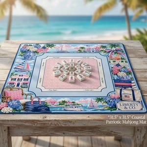 May include: A coastal patriotic mahjong mat, 31.5 x 31.5 inches, with a light blue border and a pink center. The mat features illustrations of sailboats, houses, and floral arrangements. The text "LIBERTY & CO." is visible.