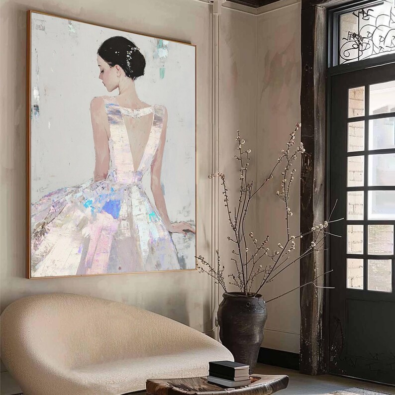Puede incluir: Pintura abstracta de una mujer con un vestido fluido, en tonos pastel suaves. La obra presenta un escote en V profundo y una espalda baja, con acentos iridiscentes en la falda. La pintura est&aacute; enmarcada en un marco de madera dorada.