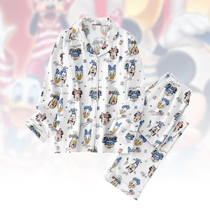 May include: White pyjama set with a repeating pattern of Disney characters, including Mickey Mouse, Donald Duck, and Minnie Mouse. The long-sleeved top has a button-down front and a notched collar. The pyjama trousers have an elasticated waistband.