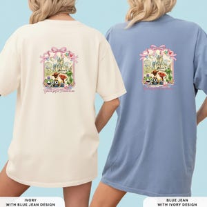 May include: Ivory and blue jean t-shirts with a graphic design on the back. The design features a castle, characters, and the text "You've got a Friend in me". The shirts are short-sleeved.