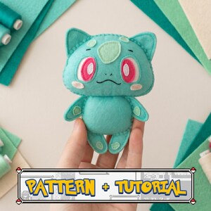 May include: A handmade teal felt Bulbasaur plushie with pink and white accents, held by a hand. The image includes spools of thread and felt squares in shades of teal and green. Text at the bottom reads "PATTERN + TUTORIAL".