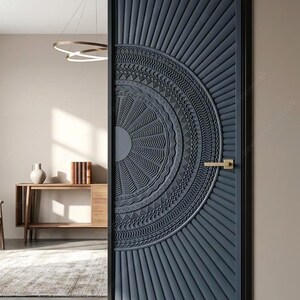 May include: A dark blue, intricately carved wooden door with a sunburst design. The door features a circular pattern in the centre and vertical lines radiating outwards. A gold-coloured handle is visible on the right side. The door is set in a black frame.