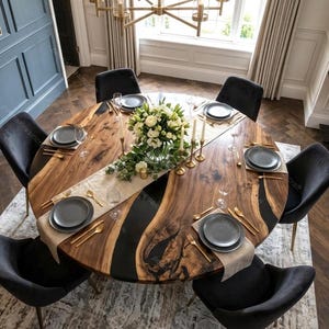 May include: A round wooden dining table with a black epoxy resin inlay, set for eight. The table features a natural wood grain pattern and is surrounded by black velvet chairs. Gold-colored cutlery and gray plates are set on a beige runner.