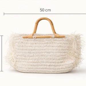 K&ouml;nnte beinhalten: Cremefarbene gewebte Tragetasche mit Bambusgriff. Die Tasche ist 50 cm breit und 26 cm hoch, mit einem Fransenrand. Der Griff ist aus gebogenem, nat&uuml;rlichem Bambus. Ein stilvolles und praktisches Accessoire f&uuml;r den t&auml;glichen Gebrauch.