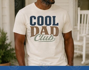 Pode incluir: Camiseta creme com o texto "COOL DAD Club" em azul marinho, castanho e verde. A camiseta de manga curta tem um design clássico de gola redonda. As palavras "DIGITAL ONLY" e "PNG JPG" estão na parte inferior.
