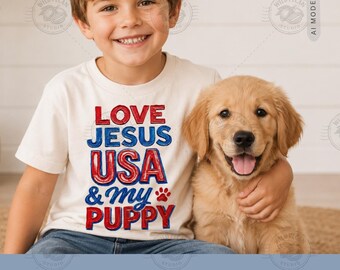 Pode incluir: Uma t-shirt de manga curta cor de creme com o texto a vermelho e azul LOVE JESUS USA & my PUPPY e um pequeno gráfico de uma pata vermelha. A t-shirt é usada por uma criança que abraça um cachorro dourado com expressão alegre.
