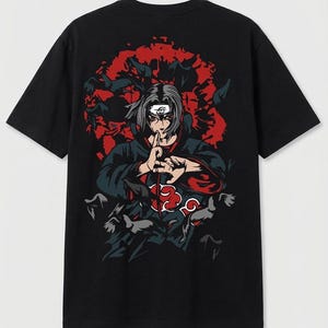 May include: Black t-shirt featuring a graphic of an anime character with gray hair, red eyes, and a black cloak. The design includes a red cloud symbol and a background of red shapes and flying birds. The character is making a hand gesture.