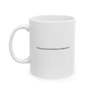 May include: A white ceramic mug with a curved handle. The mug has the text "Strong cross-functional collaborator" printed in black. The mug is designed for hot or cold beverages.