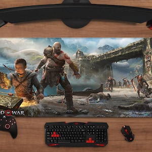 Peut inclure: Tapis de souris rectangulaire pour le jeu vidéo "God of War". L'illustration détaillée montre deux personnages dans un paysage fantastique avec un pont et des personnages en arrière-plan. Le logo du jeu est visible.