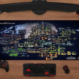 May include: A rectangular desk mat featuring a detailed, dark-toned map of Pharloom from Silksong. The design includes various labeled regions, intricate subterranean pathways, and the game title in the bottom right corner on a dark blue background.