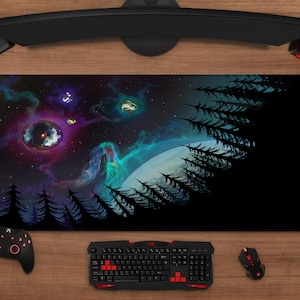 Pode incluir: Um grande tapete de rato retangular com um design cósmico vibrante com uma nebulosa, planetas e árvores silhuetadas. A paleta de cores inclui tons de roxo, azul e verde. Um teclado, rato e controlador pretos são visíveis.