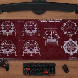 Puede incluir: Alfombrilla de ratón para juegos roja y negra con un diseño de plano de la Aries 18 Shuttle. La alfombrilla presenta diagramas y texto, con un teclado, ratón y mando negros visibles.