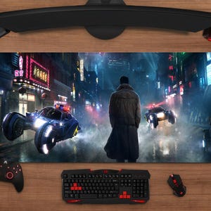 Könnte beinhalten: Ein großes rechteckiges Gaming-Mauspad mit einer futuristischen Stadtlandschaft mit fliegenden Fahrzeugen und einer Person in einem langen Mantel. Das Pad hat ein Schwarz-, Rot- und Blau-Farbschema, mit einer Tastatur, Maus und Controller sichtbar.
