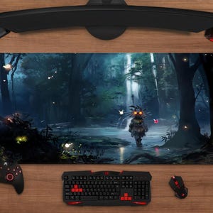 May include: A rectangular gaming mouse mat with a fantasy forest scene and a character in the water. The mat has a black border. A keyboard, mouse, controller, and headset surround the mat on a wooden surface.