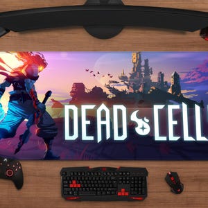 May include: A rectangular gaming mousepad featuring the "Dead Cells" game logo and artwork. The design includes a character illustration, a castle scene, and the game's title in white. A keyboard, mouse, and controller are also visible.