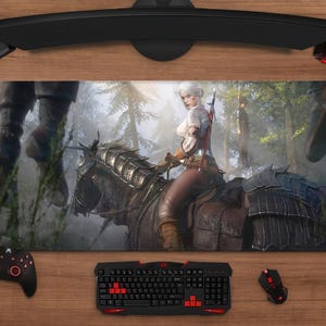 Könnte beinhalten: Rechteckiges Gaming-Mauspad mit einer Fantasy-Szene einer Frau auf einem Pferd in einem Wald. Eine Tastatur, Maus, Controller und Headset umgeben das Pad auf einer Holzoberfläche.