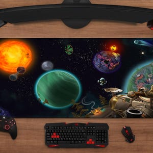 Pode incluir: Tapete de rato retangular para jogos com uma vibrante cena espacial com planetas, estrelas e um sol. O design inclui uma nave espacial e um astronauta. Um teclado, rato e controlador pretos são visíveis.