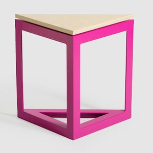 Puede incluir: Una mesa auxiliar moderna con una tapa triangular y un marco rosa brillante. La tapa de la mesa es de madera clara. La mesa tiene un diseño geométrico y es adecuada para varios estilos de interior.