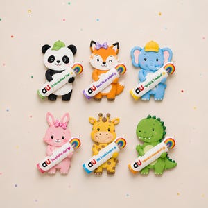 May include: Six colorful animal-shaped pencil toppers featuring a panda, fox, elephant, rabbit, giraffe, and dinosaur. Each figure holds a white pencil with a rainbow graphic and German text, including phrases like Du bist ein kleiner Star.