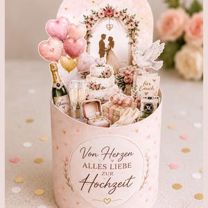May include: A decorative wedding-themed box with a romantic design. It features a cake, champagne, balloons, and a ring box. The box has the words "Von Herzen Alles Liebe zur Hochzeit" and a heart design.