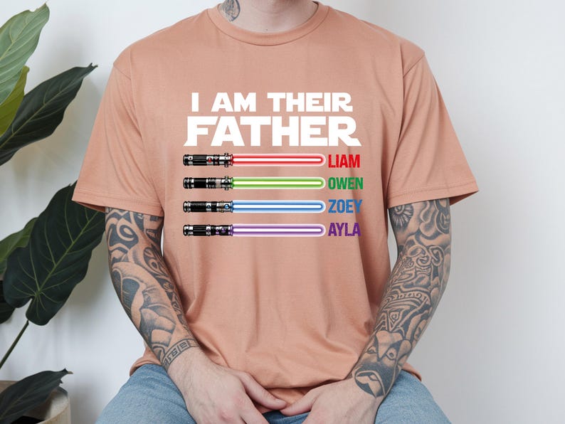 May include: A peach-colored t-shirt with the text "I AM THEIR FATHER" in white. Below the text are four lightsabers with the names Liam, Owen, Zoey, and Ayla. The lightsabers have red, green, blue, and purple blades.