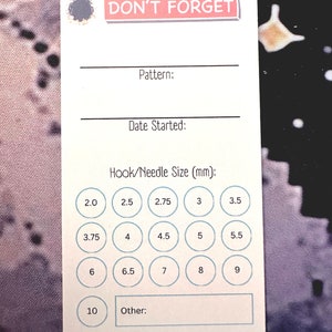 K&ouml;nnte beinhalten: Eine wei&szlig;e Karte mit dem Text "DON'T FORGET" in rosa Schrift. Die Karte hat Platz zum Aufschreiben des Musters, des Startdatums und der Haken-/Nadelgr&ouml;&szlig;e. Es gibt Kreise mit Zahlen von 2,0 bis 10,0 in Millimetern.