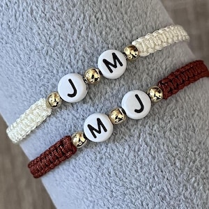 Puede incluir: Una taza de cerámica blanca con un asa negra y el texto "But First, Coffee" en negrita negra. La taza se encuentra sobre un fondo borroso, sugiriendo un ambiente acogedor.